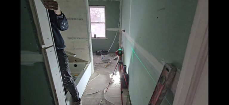 new bathroom fitted in, workman working on tiling